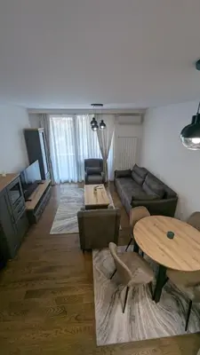a living room with a couch and a table at Planet Urban Apartment & SPA in Niš