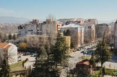 a city with buildings and a street with cars at Planet Urban Apartment & SPA in Niš