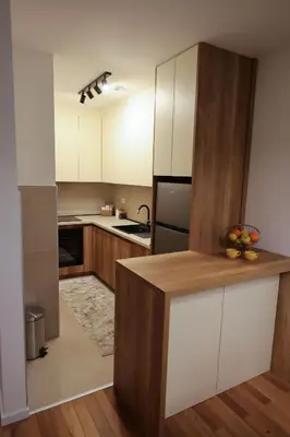 a kitchen with white cabinets and a wooden counter top at Apartment Story Nis in Niš