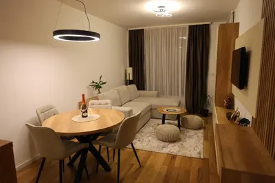 a living room with a table and a couch at Apartment Story Nis in Niš