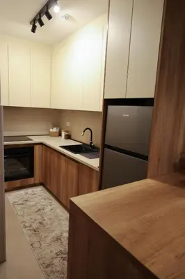 a kitchen with white cabinets and a black refrigerator at Apartment Story Nis in Niš