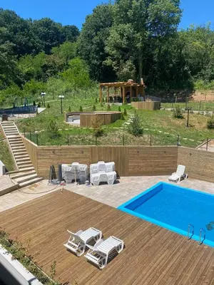 a swimming pool with chairs and a gazebo at Sunshine Lux in Vrnjačka Banja