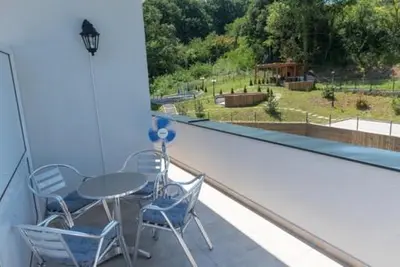 a balcony with a table and chairs and a view of a park at Sunshine Lux in Vrnjačka Banja