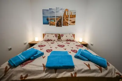 a bedroom with a large bed with blue pillows at STAN na DAN MITIC FREE PARKING in Vranje