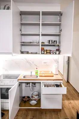 a kitchen with white cabinets and a sink at STAN na DAN MITIC FREE PARKING in Vranje