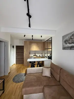 a living room with a couch and a kitchen at Royal apartmani Vrnjačka Banja in Vrnjci