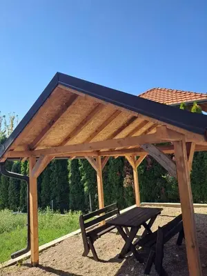 a wooden pavilion with a picnic table and a bench at Apartman S&U in Soko Banja
