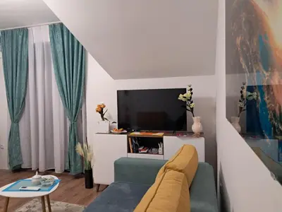 a living room with a couch and a tv at Apartman S&U in Soko Banja