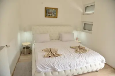 a bedroom with a white bed with bows on it at Ribarski Konaci in Ribarska Banja