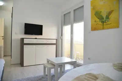 a bedroom with a bed and a table and a tv at Ribarski Konaci in Ribarska Banja