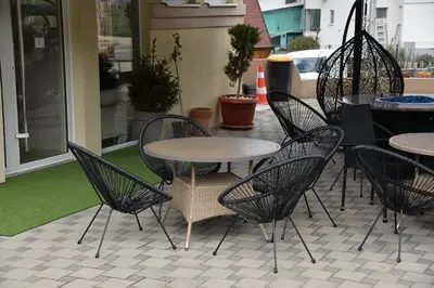 a patio with chairs and a table and tables at Ribarski Konaci in Ribarska Banja