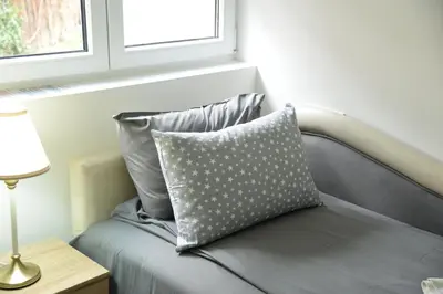 a pillow sitting on a bed next to a window at Ribarski Konaci in Ribarska Banja