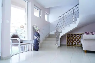 a living room with a staircase and a vase of flowers at Ribarski Konaci in Ribarska Banja