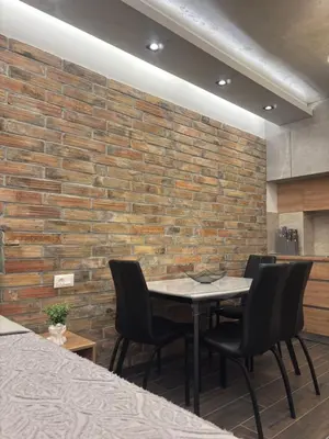 a dining room with a brick wall and a table and chairs at 