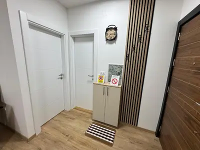 a hallway with a door and a clock on the wall at Apartman CRYSTAL Vrnjačka Banja in Vrnjačka Banja