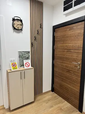 a wooden door in a room with a clock at Apartman CRYSTAL Vrnjačka Banja in Vrnjačka Banja