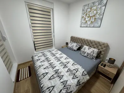 a small bedroom with a bed and a window at Apartman CRYSTAL Vrnjačka Banja in Vrnjačka Banja