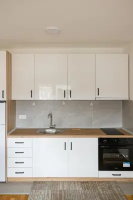 a kitchen with white cabinets and a sink at Apartman STEFAN in Vrnjačka Banja