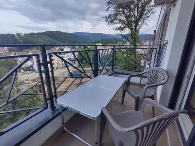 a table and chairs on a balcony with a view at Apartman STEFAN in Vrnjačka Banja