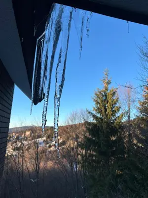 a bunch of icicles hanging from the window of a house at New Resort Treska, Kopaonik in Kopaonik
