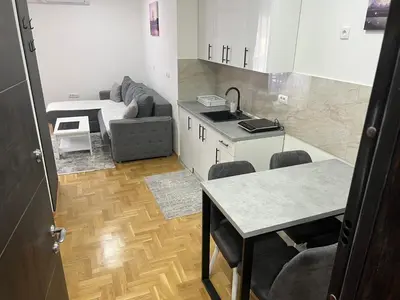 a kitchen with a couch and a table in a room at Apartman David in Vrnjci