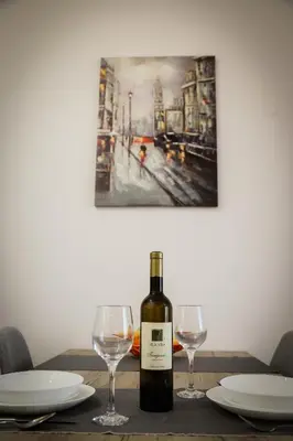 a bottle of wine sitting on a table with two glasses at Apartman NN in Vrnjci