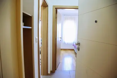 a hallway with a door to a room with a window at Apartman NN in Vrnjci