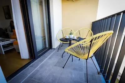 a patio with two chairs and a table on a balcony at Apartman NN in Vrnjci