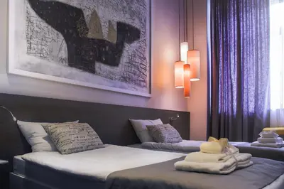 two beds in a hotel room with towels on them at Garni Hotel Eter in Niš