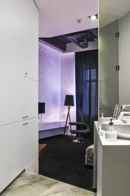 a bathroom with a sink and a desk with a chair at Garni Hotel Eter in Niš