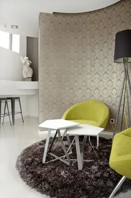 a living room with a green chair and a table at Garni Hotel Eter in Niš