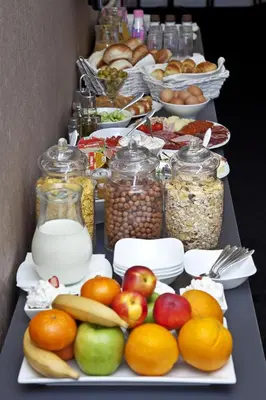 a buffet of food with fruit and jars of food at Garni Hotel Eter in Niš