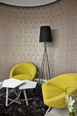 a living room with a yellow chair and a lamp at Garni Hotel Eter in Niš