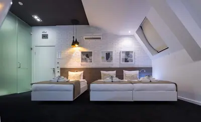 two beds in a room with two bedsitures at Garni Hotel Eter in Niš
