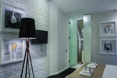 a room with a black lamp and a brick wall at Garni Hotel Eter in Niš