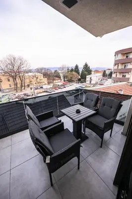 a patio with chairs and a table on a balcony at Apartmani EMA SL in Vranje
