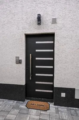 a black garage door on the side of a building at Apartmani EMA SL in Vranje