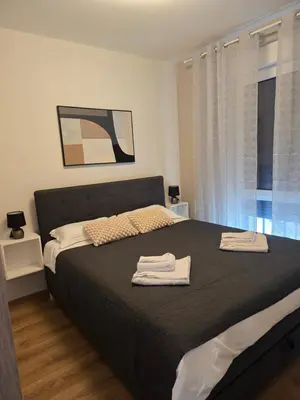a bedroom with a bed with two towels on it at Sunny lux apartman II in Vrnjačka Banja