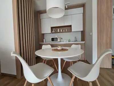 a kitchen with a white table and chairs at Sunny lux apartman II in Vrnjačka Banja