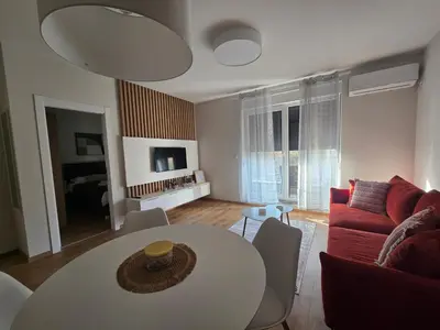 a living room with a table and a couch at Sunny lux apartman II in Vrnjačka Banja