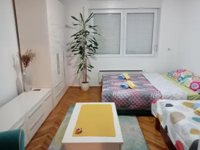 a bedroom with two beds and a table at Apartman Klinički Centar Niš in Niš