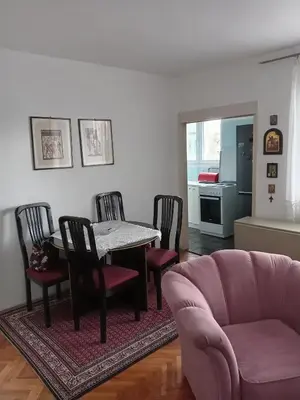 a living room with a table and chairs and a couch at Apartman Klinički Centar Niš in Niš
