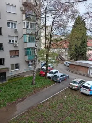 a group of cars parked in a parking lot next to a building at Apartman Klinički Centar Niš in Niš