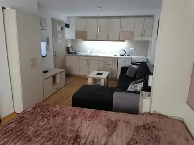 a living room with a couch and a kitchen at Royal 019 in Vrnjačka Banja