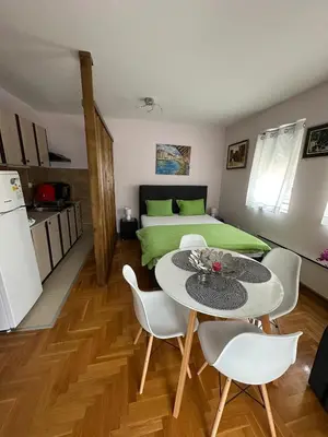 a room with a bed and a table and chairs at EDEM Apartment in Vrnjačka Banja