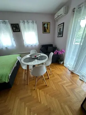 a living room with a table and chairs and a bed at EDEM Apartment in Vrnjačka Banja