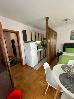 a small apartment with a kitchen and a dining table at EDEM Apartment in Vrnjačka Banja