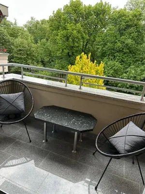 two chairs and a bench on a balcony at EDEM Apartment in Vrnjačka Banja