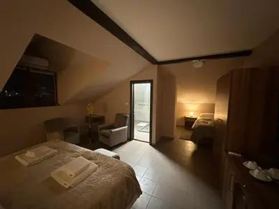 a bedroom with a bed and a living room with a window at JP Motel Mali Pariz in Bor