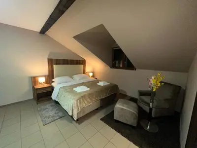 a bedroom with a bed and two tables and a vase of flowers at JP Motel Mali Pariz in Bor